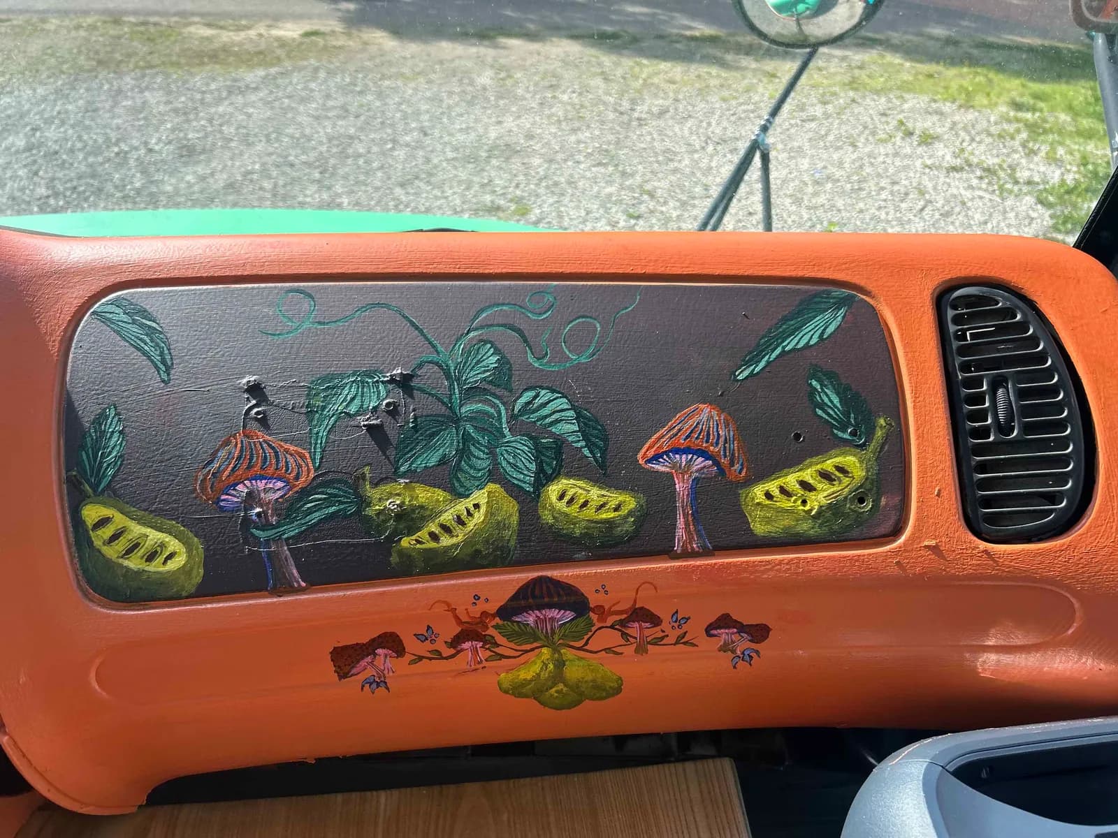 Hand-painted mushrooms, pawpaws, and birds across the bus dashboard