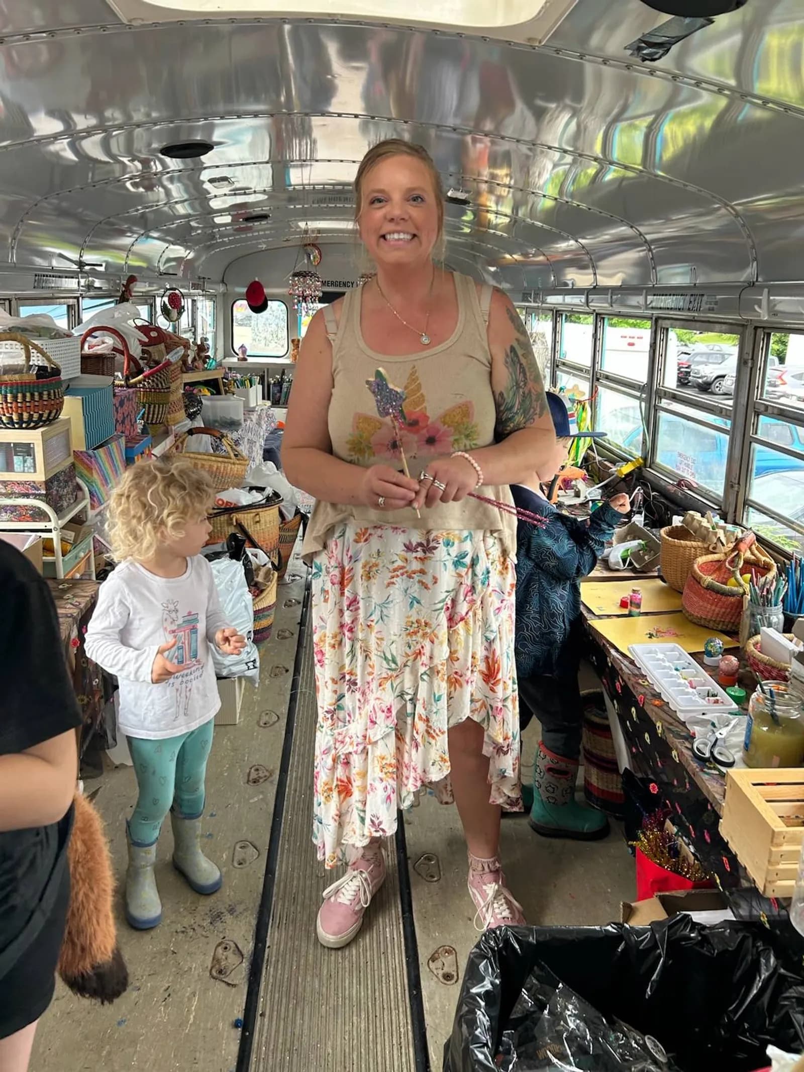 Daisy Carlson, owner of Rolly Tours, crafting aboard the bus with kids among baskets and paints