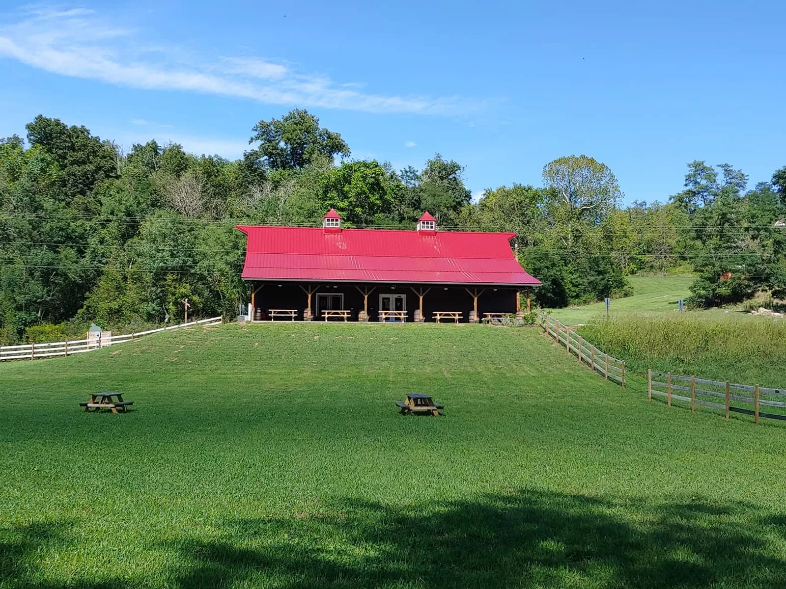 The red-roofed Dutch Creek Winery barn on a green Appalachian hillside